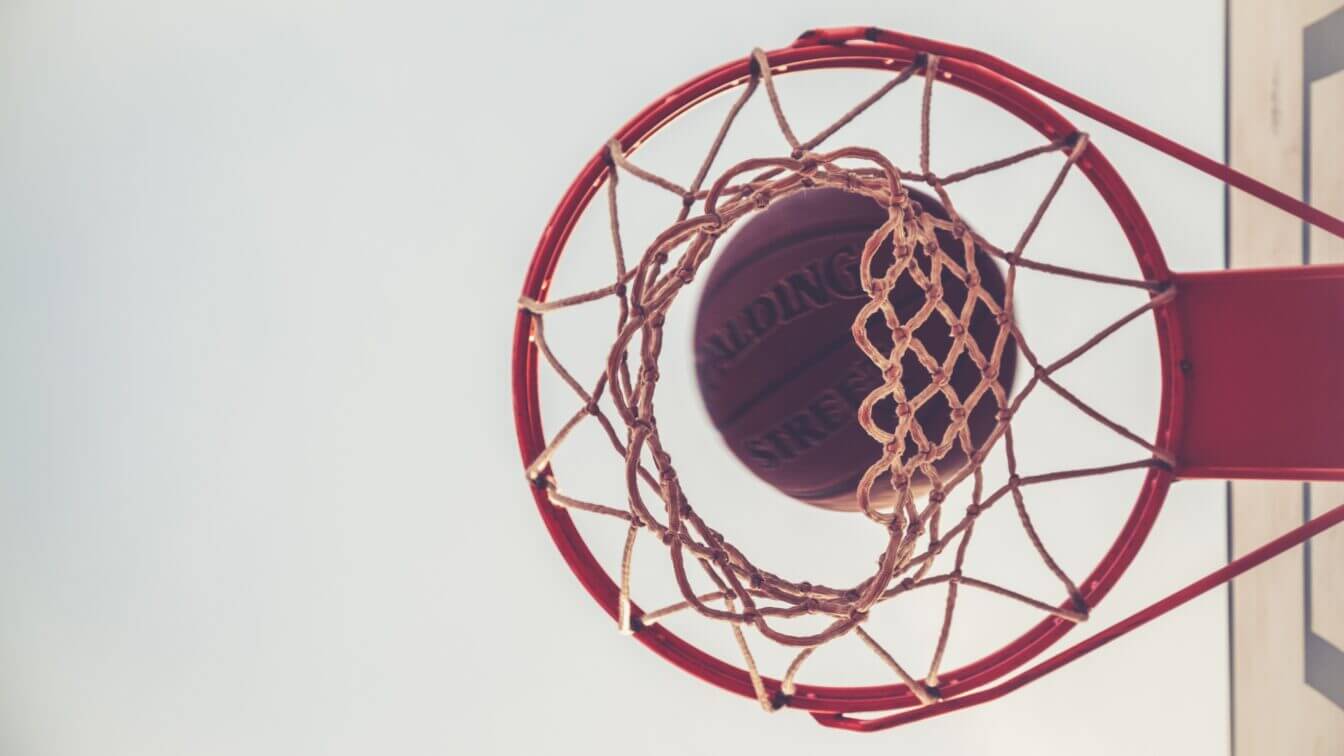 A basketball falls through a basketball hoop